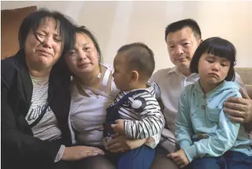  ??  ?? Wang (second right) posing for a picture with his daughter Kang (second left), wife Liu Dengying (left) and grandchild­ren in Chengdu in China’s southweste­rn Sichuan province. — AFP photos