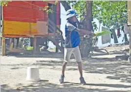  ?? Picture: JONA KONATACI ?? RIGHT: A boy does batting for a game of cricket at Korova settlement in Suva.