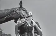  ?? BONNIE JO MOUNT/WASHINGTON POST ?? Kristen Whittaker hugs Quincy, the horse she adopted. Quincy retires after work at Arlington National Cemetery.