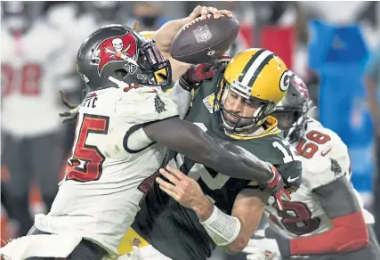  ?? Jason Behnken, The Associated Press ?? Tampa Bay linebacker Devin White, left, sacks Green Bay quarterbac­k Aaron Rodgers during the second half Sunday in Tampa, Fla. Rodgers was sacked four times in the game.