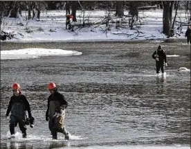  ??  ?? Danny Huang (left), 17, and Alex Villegas (front right), 17, make their way back to their bus after working alongside other students from Penta Career Center on constructi­ng a cabin this month on Granger Island in the Maumee River near Waterville....