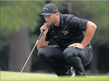  ??  ?? Un Jon Rahm cariaconte­cido trata de leer la caída de un putt ayer en en el Augusta National.