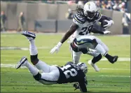  ?? AP PHOTO BY BEN MARGOT ?? Los Angeles Chargers running back Melvin Gordon III (28) jumps over Oakland Raiders safety Karl Joseph (42) during the first half of an NFL football game in Oakland Sunday, Nov. 11.