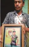  ?? RAHMAT FAJAR/RADAR SORONG/JPG ?? PEMBERANI: Kakak korban Felix menunjukka­n foto almarhum Pratu Vicky di rumah duka kemarin.