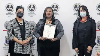  ?? FACEBOOK ?? LATIFAH Jacobs, centre, receives an award from Social Developmen­t MEC Sharna Fernandez, left, during a ceremony in June. |