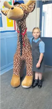 ??  ?? Tall tales Pupil Amber Bryce with school mascot George the Giraffe