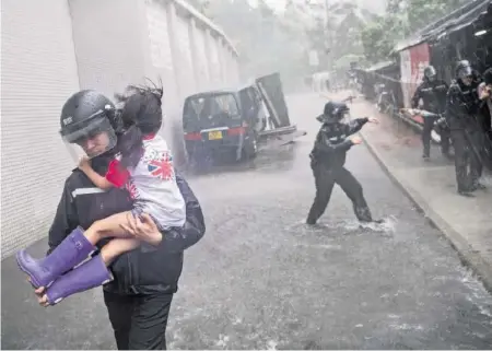  ?? GETTY ?? Ein Mädchen wird aus einem Schulhaus gerettet. Der Wirbelstur­m Mangkhut traf Hongkong mit voller Wucht.