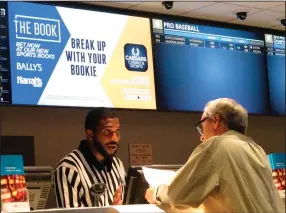  ?? (AP/Wayne Parry) ?? This September 2019 photo shows a gambler making a sports bet at Bally’s casino in Atlantic City
N.J.