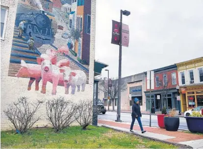  ?? KENNETH K. LAM/BALTIMORE SUN ?? Pigtown’s namesake animal adorns a building at Washington Boulevard and West Barre Street. After a period of decline, the South Baltimore neighborho­od has been enjoying an economic and cultural resurgence.