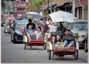  ?? Photo: VCG ?? Above: An aerial view of Penang, Malaysia Photo: IC Below: Tourists enjoy a ride in tricycle taxis in Penang, Malaysia.