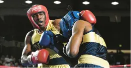  ?? ?? Kole Songonuga, in the gold trunks, defeats Nick Smith to win the 156 pound fight. The Naval Academy’s 82nd Annual Brigade Boxing Championsh­ips in February at Alumni Hall.