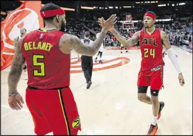  ?? CURTIS COMPTON / CCOMPTON@AJC.COM ?? Kent Bazemore, who led the Hawks with 24 points Sunday, gets a high-five from Malcolm Delaney after beating the visiting Bucks for Atlanta’s eighth win in nine games.