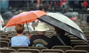  ??  ?? At right, fans had to take shelter during several downpours. But when the sun was out, so were the crowds. At left, Delta Moon’s Tom Gray, left, and Franher Joseph perform.