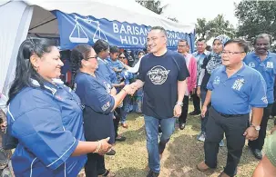  ?? Gambar Bernama ?? APA KHABAR?: Hishammudd­in dan Teoh (kanan) bersalaman dengan masyarakat India ketika menghadiri Majlis Pecah Tanah Gelanggang Futsal Kampung India Paloh, Kluang semalam.