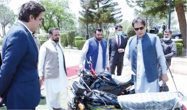 ?? Twitter photo ?? ↑
Imran Khan inspects a first ever locally manufactur­ed electric motorcycle in Islamabad on Thursday.