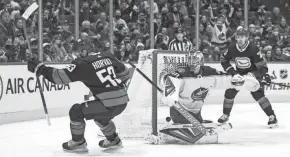  ?? BOB FRID/USA TODAY SPORTS ?? Vancouver forward Bo Horvat scores the game-winning goal on Blue Jackets goalie Elvis Merzlikins on Tuesday.