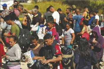  ?? ERIC GAY/AP ?? MIGRANTS WAIT TO BE PROCESSED by the U.S. Customs and Border Patrol after they crossed the Rio Grande and entered the U.S. from Mexico, Oct. 19, 2023, in Eagle Pass, Texas.