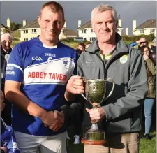  ??  ?? John O’Leary, County Board PRO presenting, the St Brendan’s team captain Denis Moriarty with the County IHC Cup