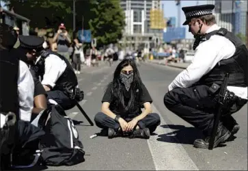  ?? Matt Dunham Associated Press ?? BRITISH police try to persuade demonstrat­ors to stop blocking the road outside the U.S. Embassy in London. Crowds also massed at U.S. embassies elsewhere, some bearing placards that read, “Stop killing black people.”