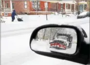  ?? TOM KELLY III — FOR DIGITAL FIRST MEDIA ?? As reflected in a sideview mirror, a snowplow passes a man snow blowing his sidewalk in the 1000 block of East High Street in Pottstown during Tuesday’s snow storm.