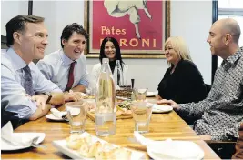  ?? NATHAN DENETTE / THE CANADIAN PRESS ?? Bill Morneau, Justin Trudeau and Bardish Chagger sit down for lunch with the owners of Pastaggio Italian Eatery in Stouffvill­e, Ont., on Monday.