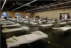  ??  ?? AP PHOTO
Cots are set up at a possible COVID-19 treatment site Wednesday in San Mateo, Calif. No patients will be immediatel­y housed in the space but proactivel­y standing it up now allows the County to be ready if and when hospitals need more medical spaces.