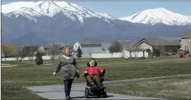  ?? THE ASSOCIATED PRESS ?? Jodi Hansen walks with her son Jacob Hansen on April 14, near their home, in Eagle Mountain, Utah.