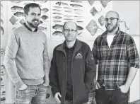  ??  ?? Eastern Nova Scotia Marine Stewardshi­p Society members Adam Mugridge, Scott Samson and Kurt Simmons stand in front of a wall display at the new Oceans of Opportunit­y Marine Science and Heritage Centre in Louisbourg during its grand opening on Thursday.