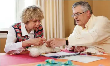  ??  ?? BELOW: Susan Johnson and her husband, David, knit together at the dining table in their Waterloo home as part of Susan’s therapy after she suffered a stroke in 2011.