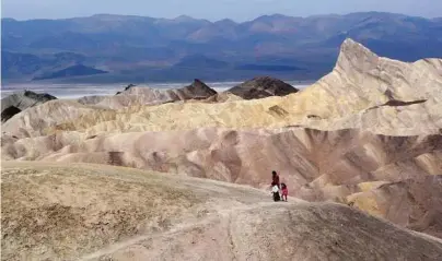  ?? Brian Melley / Associated Press file ?? Tourists walk along a ridge at Death Valley National Park, Calif.