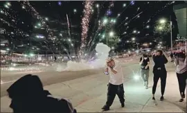  ?? Gary Coronado Los Angeles Times ?? FROM Santa Monica to the Eastside, L.A. has sounded like a war zone, Steve Lopez writes. Above, a firework explodes at a downtown L.A. protest in May.