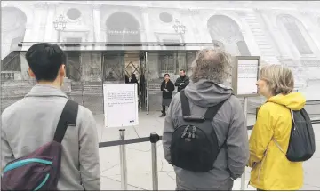  ??  ?? Tourists read informatio­n notices that indicate that the Louvre Museum is closed due to the rising Seine River in Paris, France, after days of almost non-stop rain caused flooding in the country. — Reuters photo