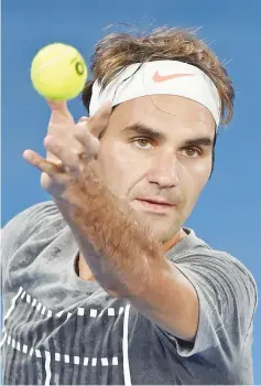  ?? - AFP photo ?? Roger Federer of Switzerlan­d serves during a practice session ahead of the Australian Open tennis tournament in Melbourne.