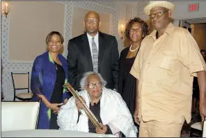  ??  ?? D.K. and Dwayne Ricks; Stephany Ricks-Fields and Shawn Ricks surround Doramae Ricks (seated), who’s holding an instrument belonging to the late inductee Snub Mosley