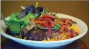  ?? ?? Carne Asada topped with bell peppers, greens and Spanish rice at Taquería and Pupusería El Torogoz in Larkspur. The dish is served with a choice of black or pinto beans and homemade tortillas.