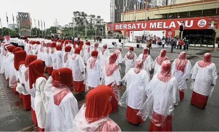  ??  ?? Members of the Umno Women and Youth movement taking part in the rehearsal for the Umno General Assembly at Plaza Merdeka, PWTC, Kuala Lumpur. — Bernama