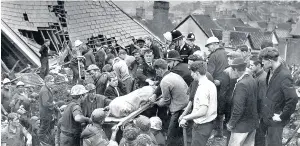  ??  ?? > Another body is brought from the shattered Pantglas Junior School in the Aberfan disaster in 1966