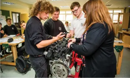  ?? Photograph: Redsnapper/Alamy ?? Teenagers work on a car engine in a mechanical engineerin­g lesson.