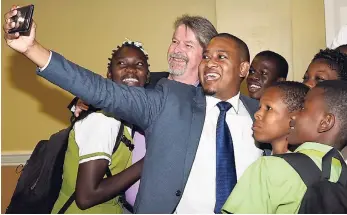  ?? FILE ?? State Minister for Education, Youth and Informatio­n Floyd Green takes a selfie with United Nations Children’s Fund (UNICEF) Jamaica Representa­tive Mark Connolly (second left) and students from Norman Manley High School following the launch of the UNICEF free social-messaging tool, U-Report, at The Knutsford Court Hotel in New Kingston in May.