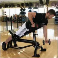  ?? (Arkansas Democrat-Gazette/Celia Storey) ?? Josh Holt, fitness director of Little Rock Racquet Club, demonstrat­es the Dumbbell Piston Row.