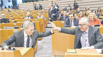  ?? — AFP photo ?? Juncker (right) and Brexit campaigner and member of the European Parliament Nigel Farage exchange a ‘high five’, at the start of the plenary session on the EU’s next long-term budget, in the European Parliament in Brussels.