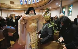  ?? KIM HAIRSTON/BALTIMORE SUN ?? In 2018, the Very Rev. Constantin­e Moralis scattered bay leaves at Vespers of Pascha at the Greek Orthodox Cathedral of the Annunciati­on in Baltimore.