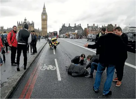  ?? PHOTO: REUTERS ?? A person who was run over during a terror attack is assisted on Westminste­r Bridge in London.