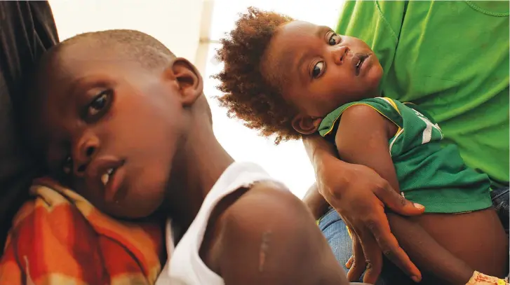  ??  ?? HAITIAN CHILDREN with cholera receive medical treatment in a provisiona­l clinic run in Port-au-Prince in 2010.