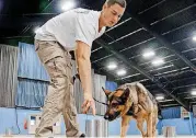 ??  ?? Jojo smells containers to detect explosive odors as he works with his handler Joseph Lafayette during a K-9 training session in Oklahoma City on Wednesday.