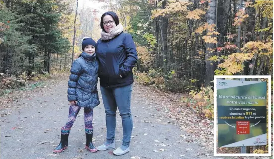  ?? PHOTOS CÉDÉRICK CARON ?? Sylvie Boucher et sa fille Naomy Huneault dans le sentier principal du parc-nature du lac Jérôme où elles ont amorcé leur randonnée de dimanche. En mortaise, une affiche qui se trouve à l’entrée du parc et qui avise d’être bien vigilant dans les sentiers.