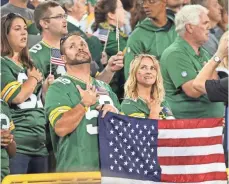  ?? DAN POWERS, APPLETON POST-CRESCENT ?? While the Packers and Bears locked arms, many fans just stood, some with hands over hearts.