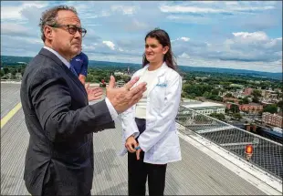  ?? AARON FLAUM/HARTFORD COURANT/TNS ?? Dr. Alan Friedman, Yale New Haven Hospital’s chief medical officer, talks with Evie Herman, 15, on the helipad at Yale New Haven Hospital as they wait for the Skyhealth helicopter in August. Evie was granted a wish through Make-a-wish to be an “oncologist for a day.”