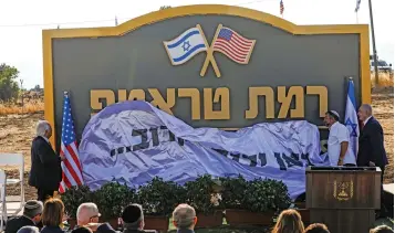  ?? (AFP) ?? This file photo shows Israeli Prime Minister Benjamin Netanyahu (right) and US Ambassador to Israel David Friedman (left) unveiling the place-name sign for the new settlement of ‘Ramat Trump’ or ‘Trump Heights’ in English, in the Golan Heights on June 16, 2019