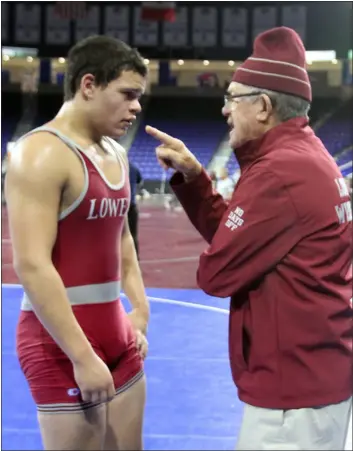  ?? JULIA MALAKIE — LOWELL SUN ?? Lowell High wrestling coach George Bossi gives pointers to Aaron Diaz prior to an 195-pound match at the Bossi Holiday Tournament at the Tsongas Center in Lowell on Dec. 28, 2018.